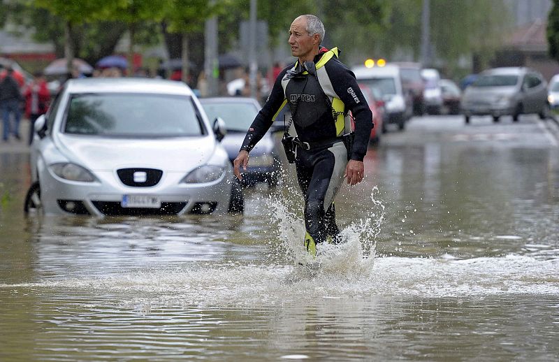 Un bombero atraviesa una de las calles inundadas de Pamplona