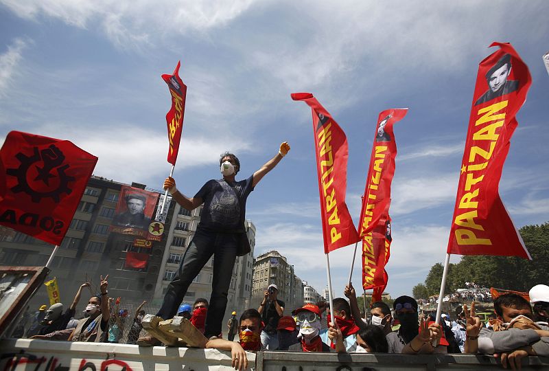 Protesters stand behind a barricade during a protest at Taksim Square in Istanbul