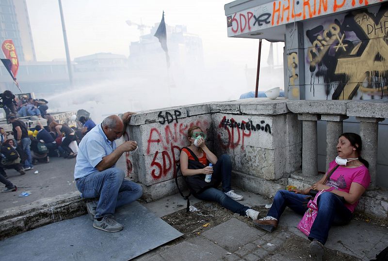 Protesters affected by teargas rest during a protest at Taksim Square in Istanbul