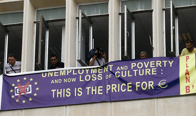 Empleados de la radiotelevisión pública ERT observan desde el interior de la emisora la concentración de apoyo