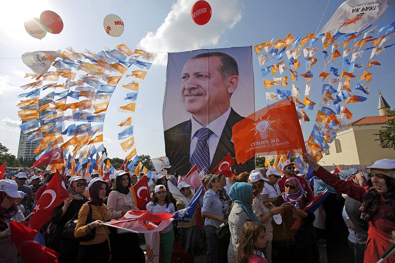 Mientras, seguidores del partido AK portan un poster del primer ministro Tayyip Erdogan