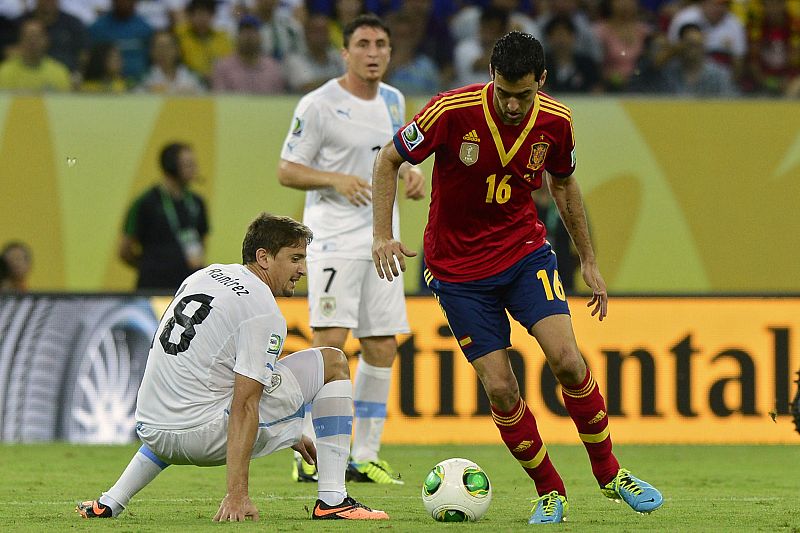Sergio Busquets dribla al uruguayo Ramírez en una jugada del partido España - Uruguay en la Copa Confederaciones