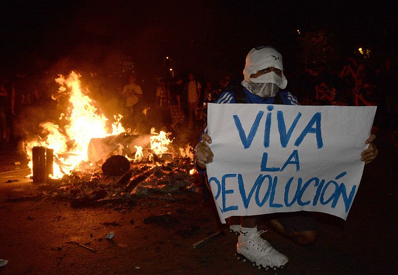 Uno de los manifestantes sostiene un cartel en el que se lee "Viva la Revolución", durante las protestas que han tenido lugar este lunes en Rio de Janeiro,  así como en otras grandes ciudades de Brasil