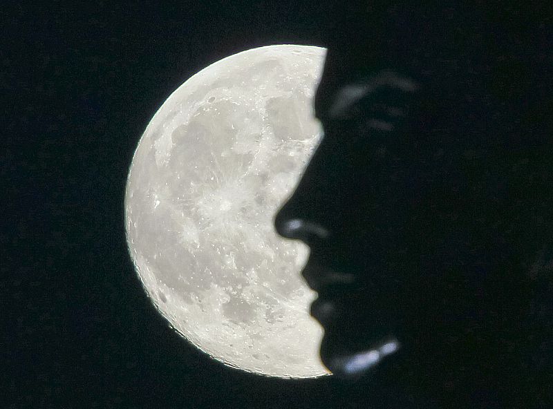 Supermoon rises La superluna asciende en el cielo perfilando la cabeza de una estatua en Kievover Kiev.