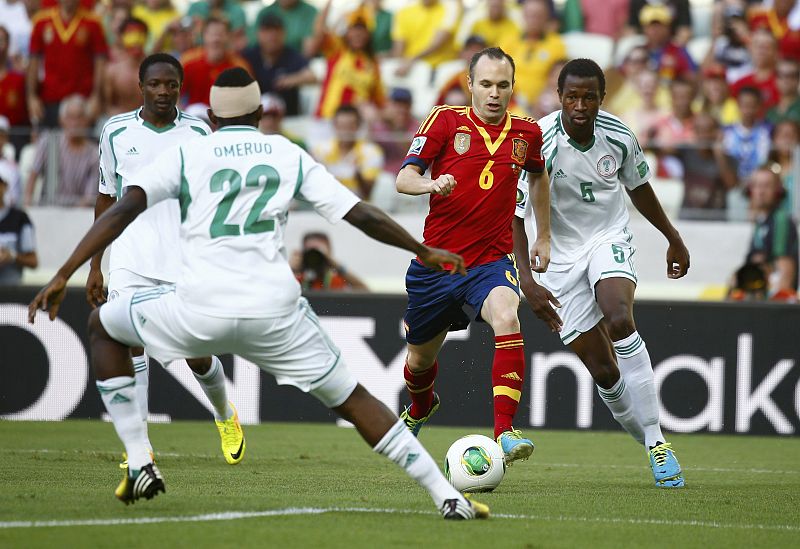 Iniesta controla el balón entre tres rivales nigerianos.