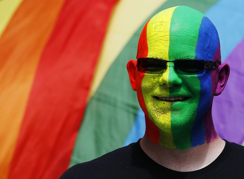 A participant poses with rainbow flags during the annual Pride London parade