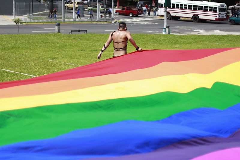 A reveller carries a rainbow flag during the gay pride parade in San Salvador