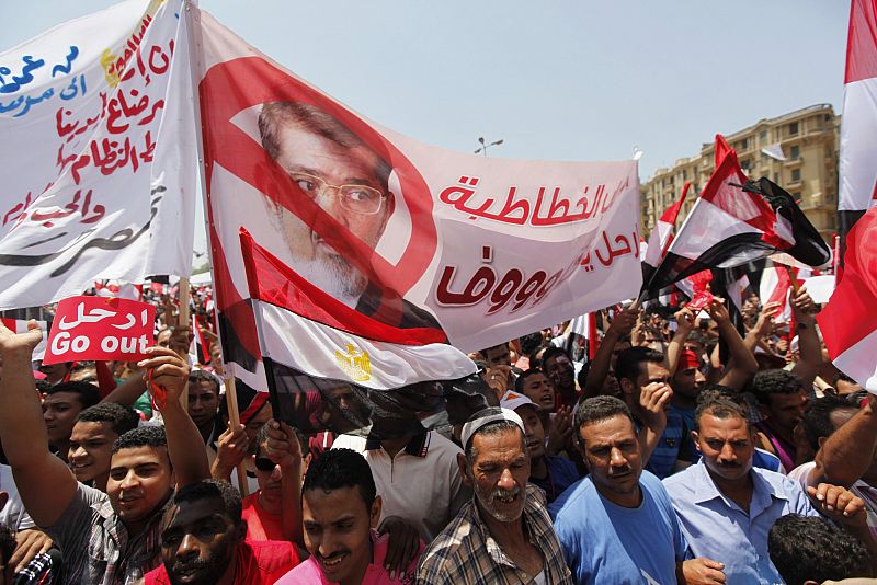 Protesters opposing Egyptian President Mursi hold up a banner during a protest at Tahrir square in Cairo