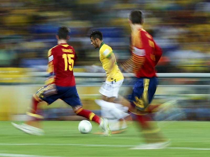 Neymar corre con el balón entre Sergio Ramos y Gerard Piqué.