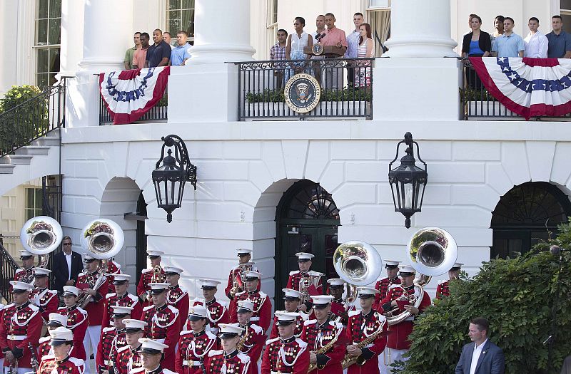 U.S. President Obama speaks to guests next to the First lady during Independence Day celebrations on the South Lawn of the White House in Washington