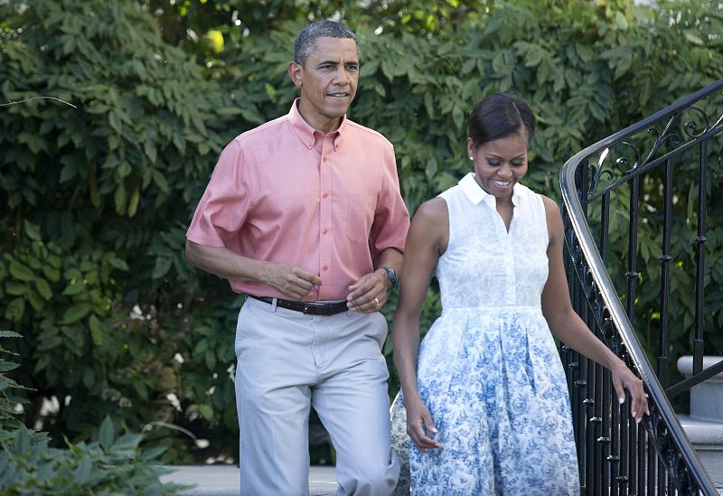 U.S. President Obama and the First lady walk down the stairs during Independence Day celebrations on the South Lawn of the White House in Washington