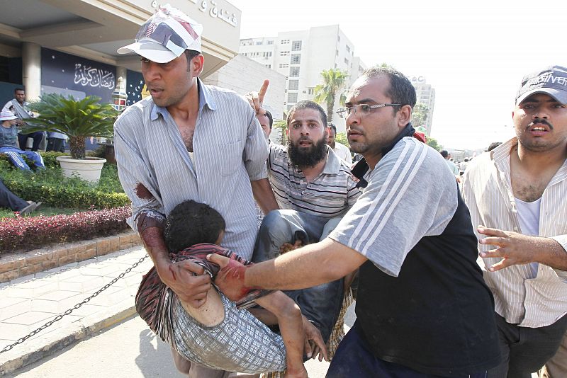 Manifestantes a favor de Morsi trasladan a un herido durante los enfrentamientos.