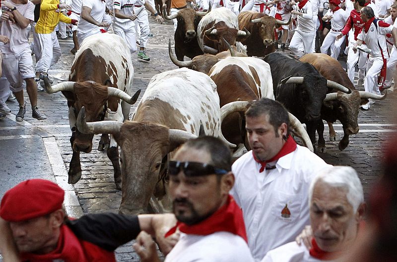 Los mozos corren por la Curva de Mercaderes delante de los toros de la ganadería toledana de Alcurrucén.