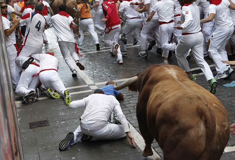 Varios mozos tienen apuros, por la Curva de Mercaderes, delante de los toros de la ganadería toledana de Alcurrucén.