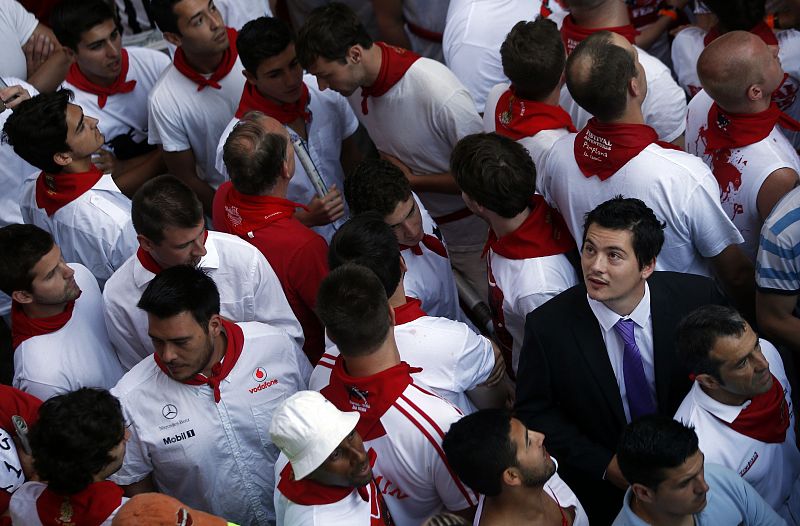 Un corredor trajeado espera entre la multitud del segundo encierro de San Fermín 2013