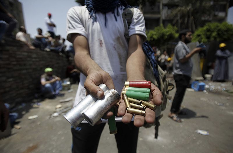 A member of the Muslim Brotherhood and supporter of Mursi displays spent ammunition after clashes with army in front of Republican Guard headquarters in Nasr City