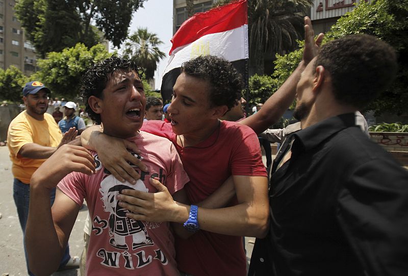 Members of the Muslim Brotherhood and supporters of Mursi react at Republican Guard headquarters in Nasr City