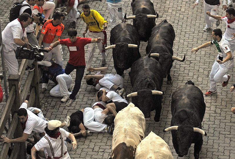 Varios mozos caen al suelo, en el tramo del callejón