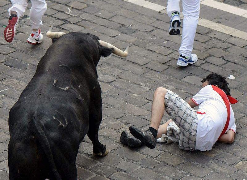 Un mozo cae en el tramo del Ayuntamiento al paso de los toros de la ganadería madrileña de Victoriano del Río