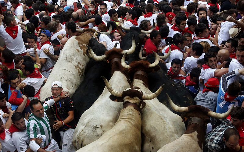 Runners get trapped with Fuente Ymbro fighting bulls during the seventh running of the bulls of the San Fermin festival in Pamplona