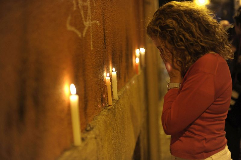 Una turista estadounidense llora frente a las velas tras entonar el "Pobre de mí" que pone fin a las fiestas de San Fermín.