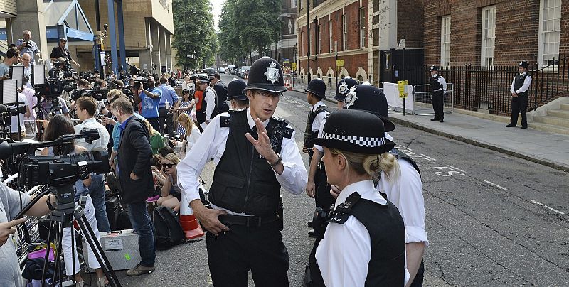 Policías y numerosos medios de comunicación aguardan en el exterior del hospital St.Mary's, donde la duquesa Catalina de Cambridge ha sido hospitalizada para dar a luz, en Londres este lunes 22 de julio de 2013.