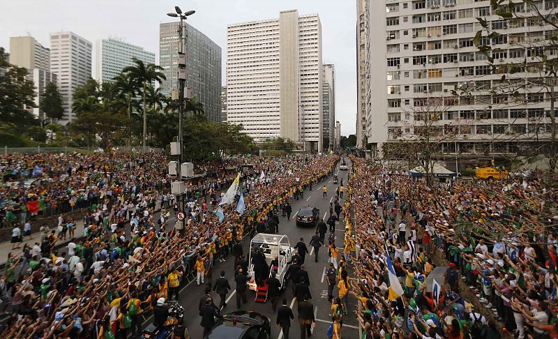 El papa saluda desde el papa-móvil a los miles de fieles que han salido a las calles de Río de Janeiro para darle la bienvenida a la JMJ que este año se celebra en Brasil