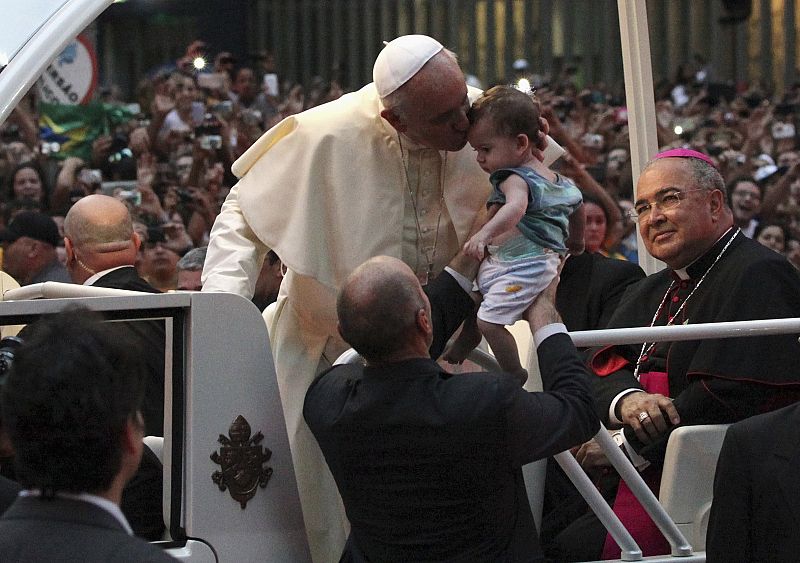 El papa besa a un bebé durante su recorrido por las calles de Río de Janeiro con motivo de la celebración de la JMJ en Brasil
