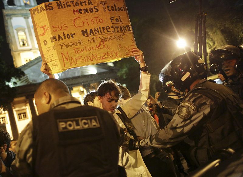 Uno de los participantes de las protestas contra la visita del papa sostiene un cartel en el que se lee: "Más Historia, menos Teología. Jesús fue el mayor manifestante de todos los tiempos y fue marginado"