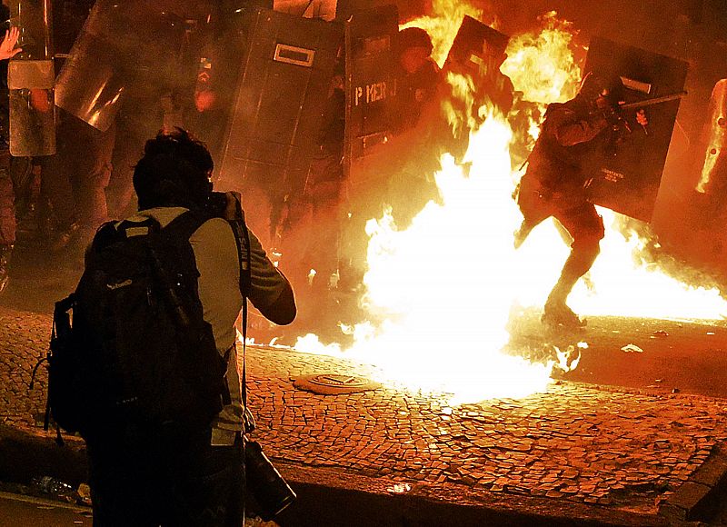 Yasuyoshi Chiba, el fotógrafo de AFP herido durante las protestas, fotografía a los policías antidisturbios rodeados por el fuego de los cócteles molotov en Río de Janeiro, Brasil