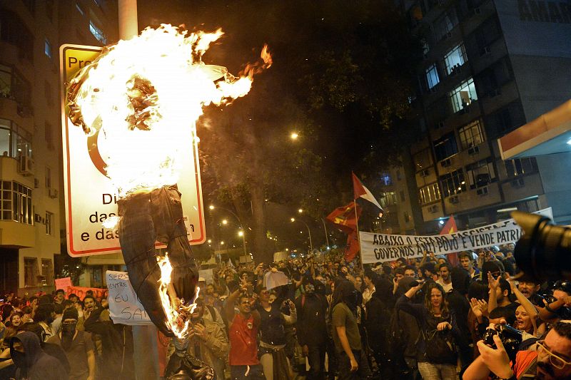 Los manifestantes han quemado un muñeco que representaba al gobernador de Río de Janeiro, como parte de las protestas contra los 53 millones de dólares brasileños procedentes de arcas públicas nvertidos en la visita del papa