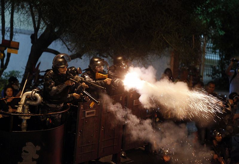 Los policías antidisturbios disparan gases lacrimógenos y bolas de goma para disolver las protestas contra la visita del papa en Río de Janeiro