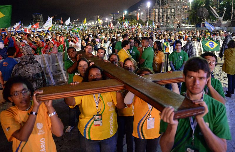 Un grupo de jóvenes transporta la Cruz de los Jóvenes, que ha presidido la misa inaugural de la JMJ en la playa de Copacabana, en Río de Janeiro, Brasil