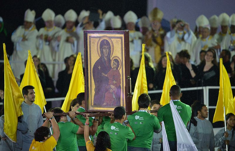 Un grupo de fieles porta las imágenes de la Virgen María y Jesucristo que han presidido la eucaristía inaugural de la JMJ