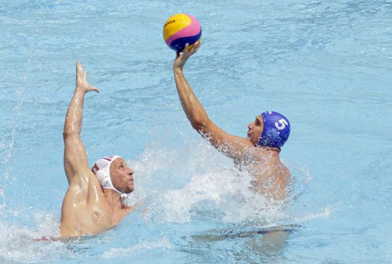 El waterpolista Marton Vamos controla el balón ante la defensa del serbio Andrija Prlainvovi durante el partido correspondiente a la fase preliminar de los Campeonatos del Mundo de Natación disputado hoy en las Piscinas Picornell de Barcelona. Serbia