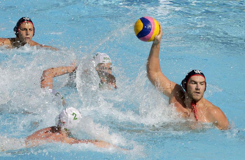 El waterpolista estadounidense John Mann controla el balón ante el sudafricano Etienne le Roux durante el partido correspondiente a la fase preliminar de los Campeonatos del Mundo de Natación disputado hoy en las Piscinas Picornell de Barcelona.