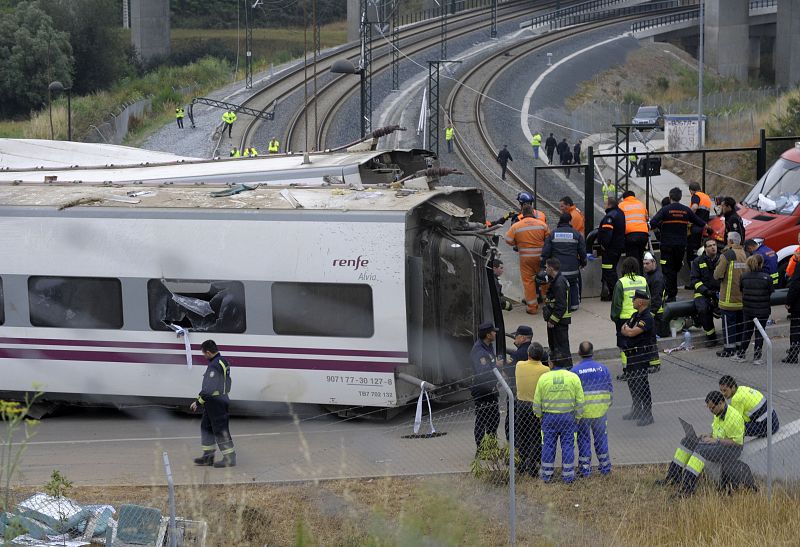 Operarios, forenses y oficiales de la policía examinan el lugar donde ha descarrilado un tren en la noche del miércoles cerca de Santiago de Composte.