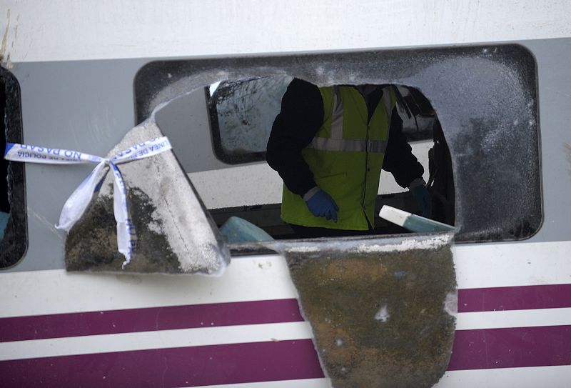 Un miembro de los equipo de rescate camina por dentro de uno de los vagones del tren siniestrado.
