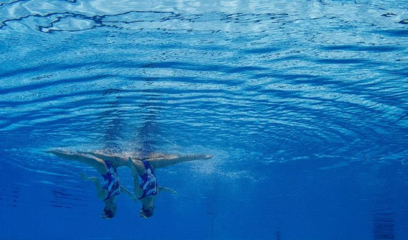 Las chinas Tingting Jiang y Wenwen Jiang ejecutan su ejercicio en la final de rutina libre dúos Sincronizada en la piscina del Palau Sant Jordi de Barcelona.