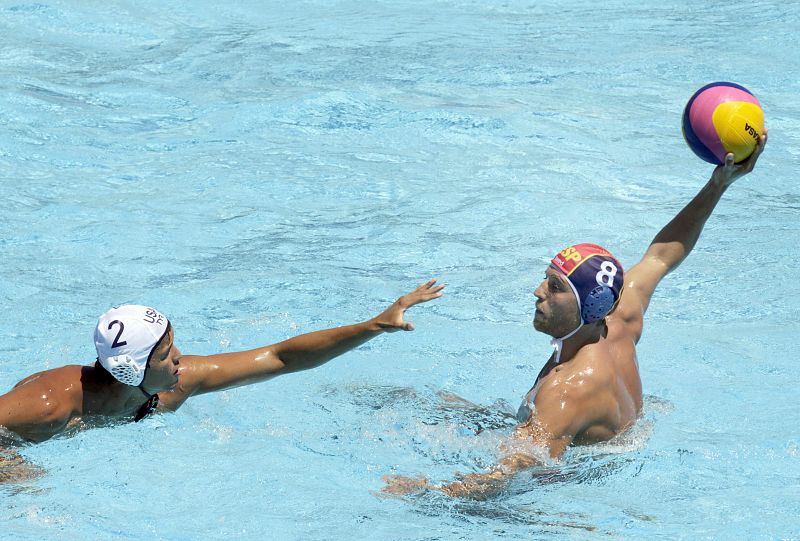 El waterpolista español Albert Español controla el balón ante el estadounidense Janson Wigo durante el partido de octavos disputado en las Piscinas Picornell de Barcelona. España ha ganado por 10 a 6.