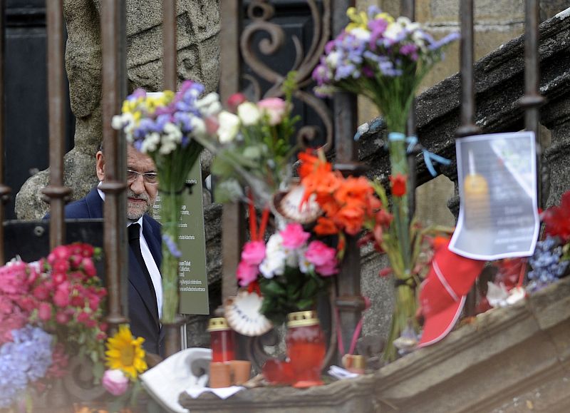 El presidente del Gobierno, Mariano Rajoy, observa una ofrenda de flores en la plaza del Obradoiro