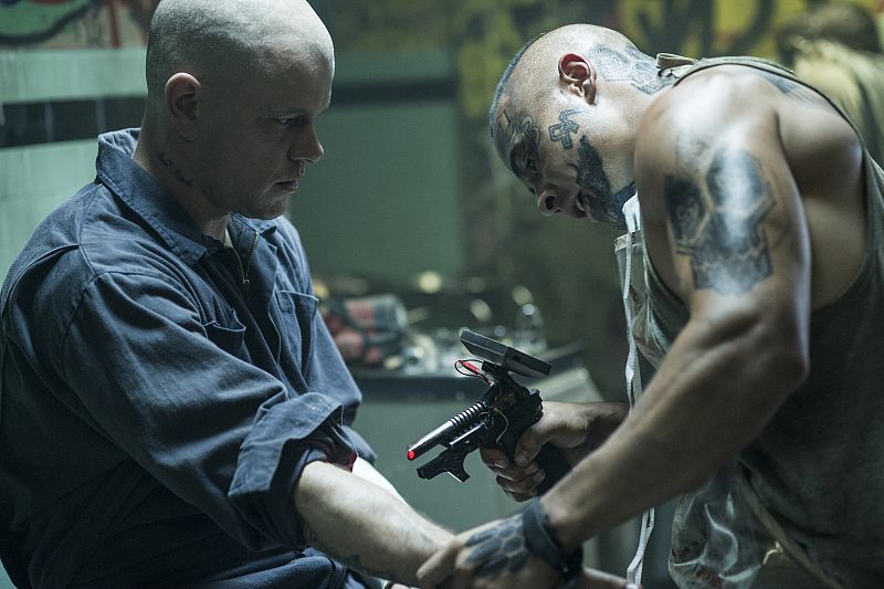 Sandro (José Pablo Cantillo) preps Max (Matt Damon) para someterse a una operación en La Guarida de la Araña