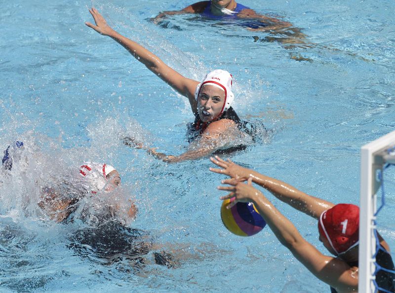 La waterpolista griega Antigoni Roumpesi tira ante la defensa de la portera canadiense Michele Relton durante el partido correspondiente a la fase preliminar de los Campeonatos del Mundo.