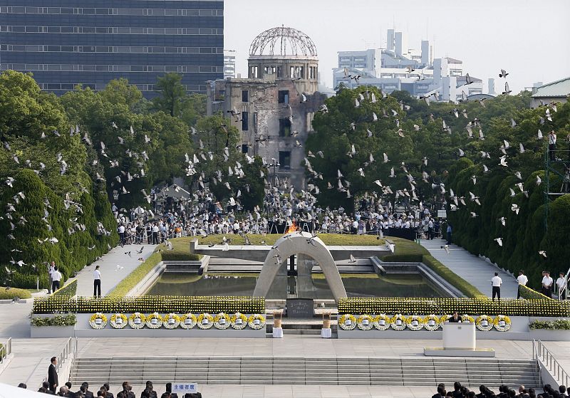 Una bandada de palomas vuela sobre el Domo de la Bomba Atómica en el Parque Monumento de Paz en Hiroshima (Japón). Las palomas fueron liberadas para recordar a las víctimas de la bomba atómica durante la ceremonia que marca el aniversario número 68