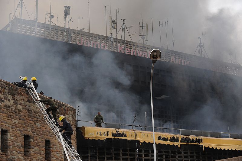 Los bomberos trepan hasta la terminal calcinada del del Aeropuerto Internacional Jomo Kenyatta en Nairobi (Kenia).