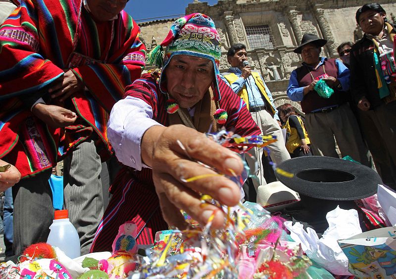 Un sacerdote aimara coloca una ofrenda a Pachamama durante las celebraciones que agradecen a la Madre Tierra la producción agrícola y la prosperidad de las familias