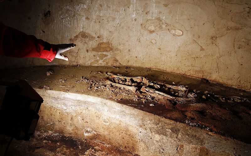 Researcher shows remains inside a tomb opened in the stone church floor above the family crypt of Florentine silk merchant del Giocondo in the Santissima Annunziata basilica in Florence