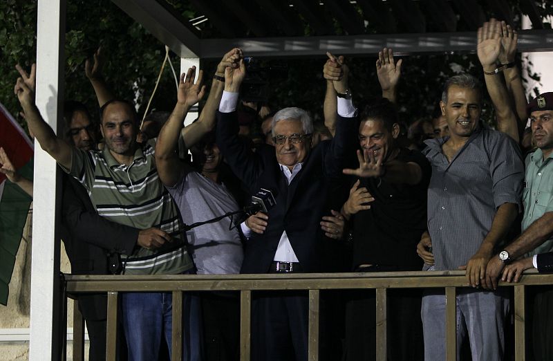 El presidente palestino, Mahmud Abás (centro), recibe en la sede del Gobierno en Ramala a once de los veintiséis reclusos palestinos liberados por Israel