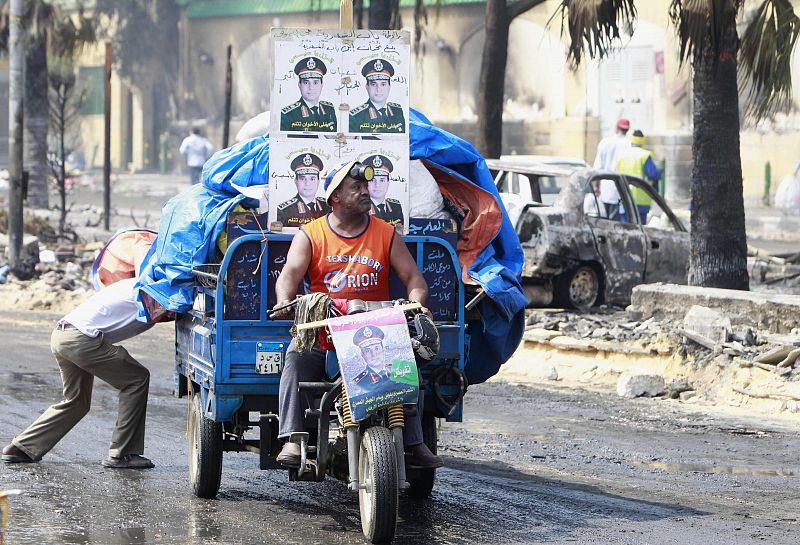 Un hombre transporta en su motocicleta carteles del ministro de Defensa, Abdel Fattah de Egipto al-Sisi.