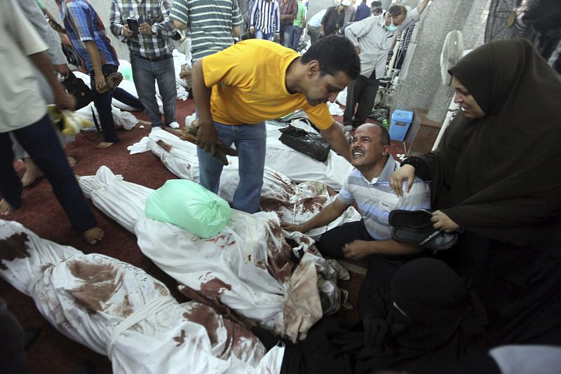 Varias personas permanecen junto a docenas de cadáveres de familiares en la mezquita al-Imene en El Cairo